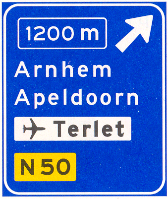 Verkeersbord K2: Voorwegwijzer langs autosnelweg voor de afgaande richting, met afstandaanduiding, afritnummer, interlokale doelen (bovenste doel = afritnaam), verwijzing naar vliegveld/luchthaven en routenummer niet-autosnelweg