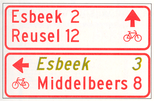 Verkeersbord K8: Wegwijzer voor fietsers en bromfietsers (stapelbord), met interlokale doelen en een via een alternatieve route te bereiken doel (cursief)
